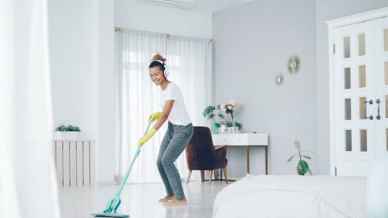Woman mopping a bright kitchen floor - house cleaning cost in Dallas-Fort Worth